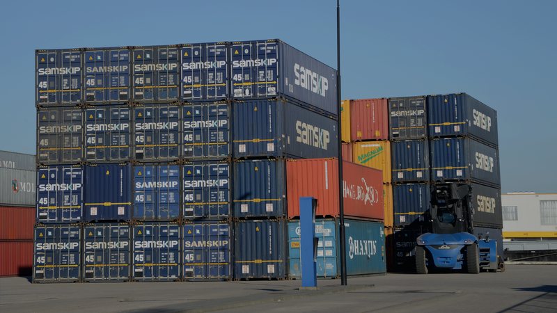 Foto: Containerterminal mit gestapelten Seecontainern und Portalkran — Symbolbild aus dem Bildpool der Rubrik, nicht vom Ereignis selbst.