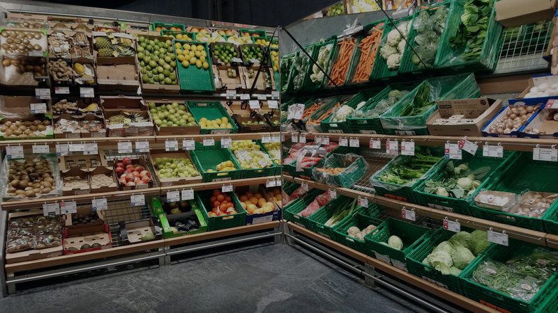 Foto: Früchte- und Gemüseregal in einer Schweizer Coop-Filiale, an den Warenkisten hängen die Preisschilder.